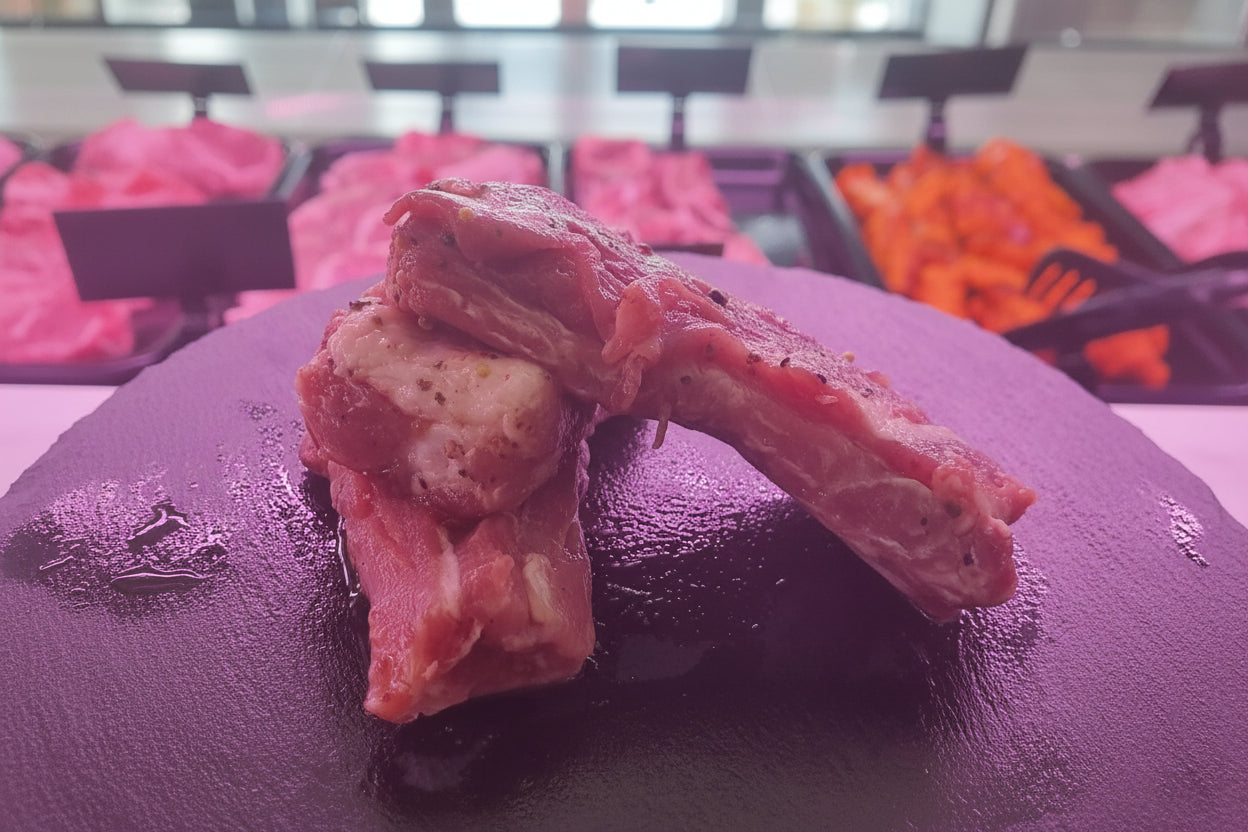 Costine di suino marinate con grani di pepe rosa, preparate per una cottura aromatica e saporita.
