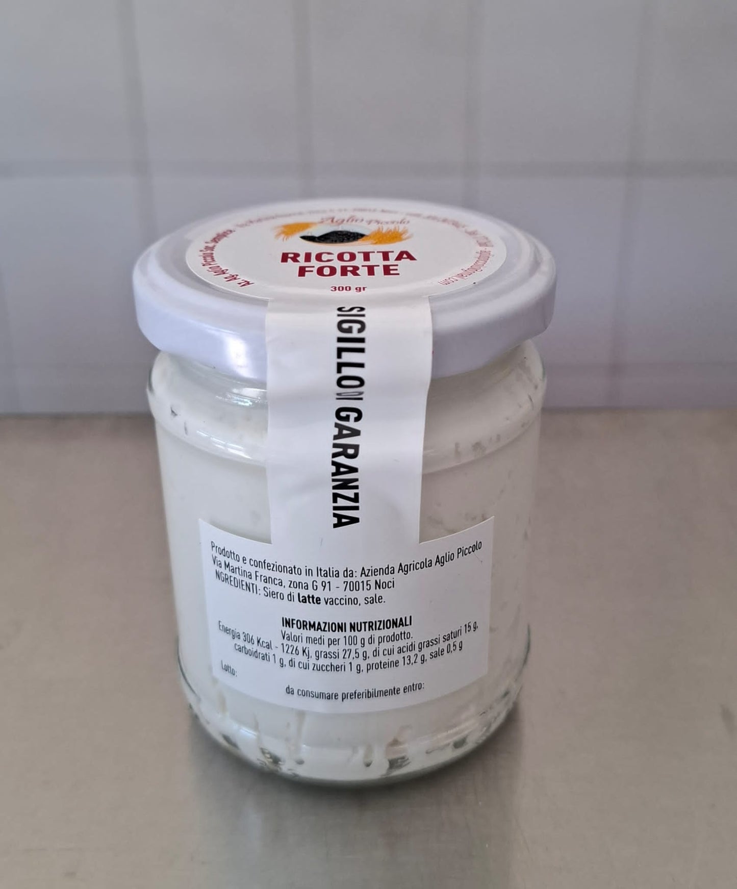 Ricotta forte in glass jar, traditional Pugliese fermented cheese, ideal for pasta, panzerotti, or bread.