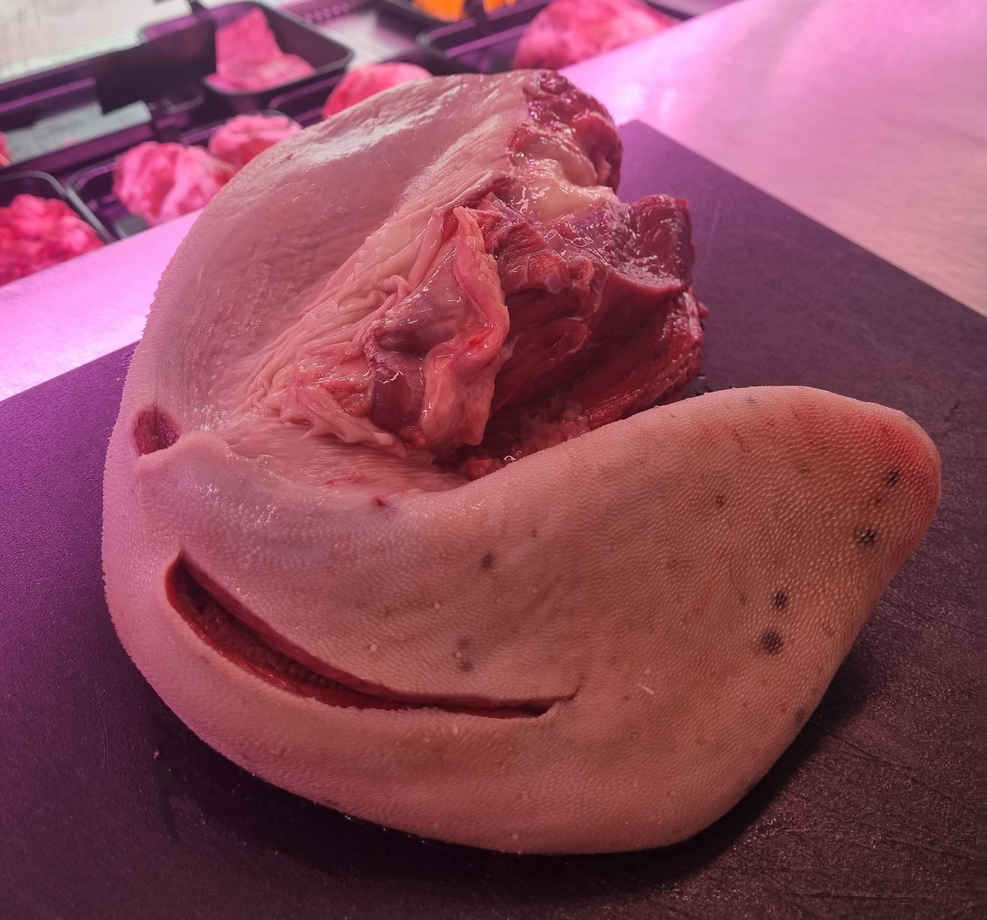 Lingua di bovino fresca su un tagliere, evidenziando la sua texture e il taglio di carne.