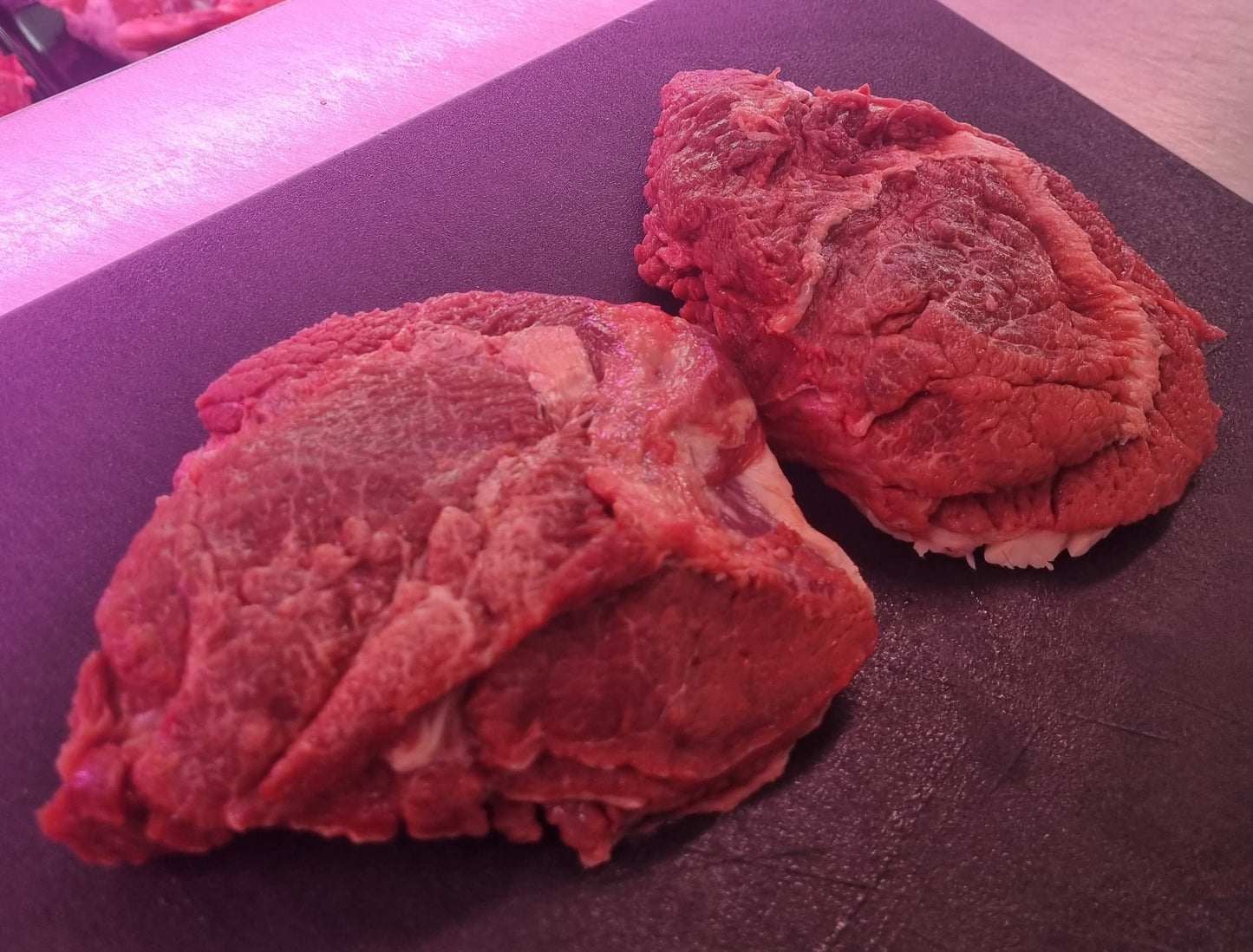 Guancia di bovino fresca su un tagliere, evidenziando la consistenza e il colore della carne.